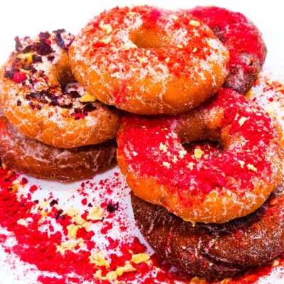 gluten free and vegan donuts sitting on a plate, topped with dried fruits